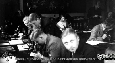 Fotoalbum "Kursen i histologi H T 1932.
Fotoalbum "Kursen i histologi H T 1932".  Bildtext "Sällskapsliv". Troligen medicine studerande vid  kursmikroskop på histologiska avdelningens mikroskoperingssal på anatomiska institutionen i Lund. 
Bildkälla stiftelsen Locus Medicus Lundensis och Sydsvenska Medicinhistoriska Sällskapet / SMHS. Fotograf okänd.
Nyckelord: Universitetet i Lund;Locus Medicus Lundensis;Anatomiska Institutionen;Histologiska avdelningen;Sydsvenska Medicinhistoriska Sällskapet;SMHS;Medicine studerande