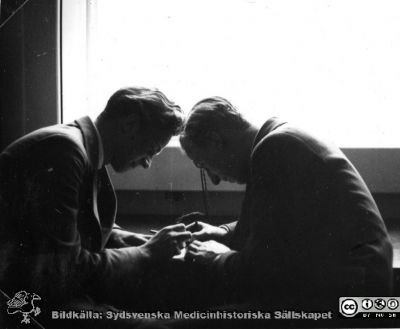 Fotoalbum "Kursen i histologi H T 1932.
Fotoalbum "Kursen i histologi H T 1932".  Bildtext "Wideförhör. Vem vinner bondeschacken, Ståhl eller Rosberg?", rimligen under ett segt förhör av amanuensen Wide.  Kan också ses som en fortsättning på bildserien "Sällskapsliv". Troligen medicinare under studier på histologiska avdelningens mikroskoperingssal på anatomiska institutionen i Lund. 
Bildkälla stiftelsen Locus Medicus Lundensis och Sydsvenska Medicinhistoriska Sällskapet / SMHS. Fotograf okänd.
Nyckelord: Universitetet i Lund;Locus Medicus Lundensis;Anatomiska Institutionen;Histologiska avdelningen;Sydsvenska Medicinhistoriska Sällskapet;SMHS;Medicine studerande;Amanuensförhör