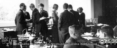Fotoalbum  "Kursen i histologi H T 1932.
Fotoalbum "Kursen i histologi H T 1932".  Bildtext "Uppbrott", rimligen efter någon föreläsning. Kan också ses som en fortsättning på bildserien "Sällskapsliv". Troligen medicinare under studier på histologiska avdelningens mikroskoperingssal på anatomiska institutionen i Lund. 
Bildkälla stiftelsen Locus Medicus Lundensis och Sydsvenska Medicinhistoriska Sällskapet / SMHS. Fotograf okänd.
Nyckelord: Universitetet i Lund;Locus Medicus Lundensis;Anatomiska Institutionen;Histologiska avdelningen;Sydsvenska Medicinhistoriska Sällskapet;SMHS;Medicine studerande