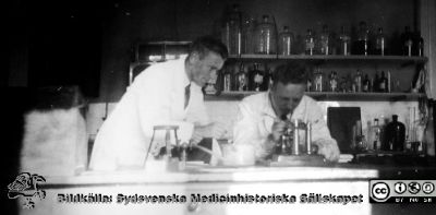 Fotoalbum  "Kursen i histologi H T 1932
Fotoalbum  "Kursen i histologi H T 1932".  Bildtext "Myotomen". Men kanske är det i själva verket en mikrotom som männen arbetar vid. Troligen medicinare under studier på histologiska avdelningens kurslaboratorium på anatomiska institutionen i Lund. 
Bildkälla stiftelsen Locus Medicus Lundensis och Sydsvenska Medicinhistoriska Sällskapet / SMHS. Fotograf okänd.
Nyckelord: Universitetet i Lund;Locus Medicus Lundensis;Anatomiska Institutionen;Histologiska avdelningen;Sydsvenska Medicinhistoriska Sällskapet;SMHS;Medicine studerande