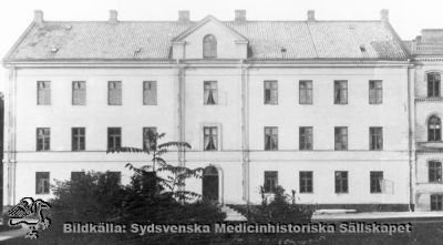 Lunds lasarett, byggt 1848-1850.  Från 1868 i sin helhet medicinsk klinik. Från 1918 radiologisk klinik i bottenvåningen. T h (öster) om den låg dåvarande ögonkliniken. Foto omkring 1890. 

