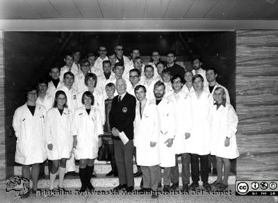 Medicinarkursen i kirurgi i Lund höstterminen 1969
Prof. Philip Sandblom i centrum, i kavaj med universitetsemblemet. Han hade just pensionerats. Det togs samtidigt en annan bild där kursamanuensen är med. Se denna för namn på bildens kursdeltagare.
Foto i det alldeles nya centralblockets entrétrappa upp till aulan.
Omonterat och omärkt foto.
Nyckelord: Lund;Lasarett;Universitet;Universitetssjukhus;USiL;Utbildning;Kirurgi;Kurs;Kandidater;Medicine