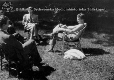 Nils-Åke Hillarp (1916-1965) 
Här som amanuens med bar överkropp i förhör med anatomi / histologi-studenter i Lund. Dessa är betydligt prydligare uppklädda. Foto på 1940-talet. 
Nils-Åke Hillarp var soldyrkare och dog i ett malignt melanom, bara 49 år gammal. Han hade då hunnit bli professor i histologi vid Karolinska Institutet i Stockholm.
Nyckelord: Amanuens;Nils-Åke;Hillarp;Histologi;Professor;Karolinska;Institutet