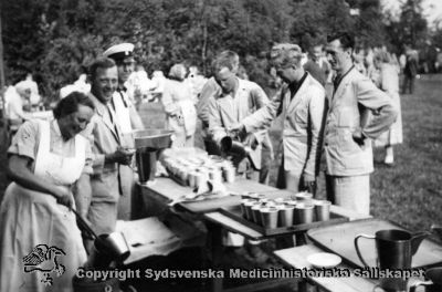 Vipeholmare på utflykt i det gröna.
Vipeholm fester. Kalle Westerdahl till höger, bortom bordet. Foto Omonterat
Nyckelord: Vipeholm;Fest;Foto;Omonterat;Kapsel 14