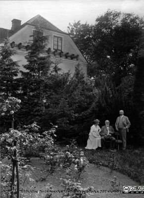 M. K. Löwegren i sitt hem på S:t Petri Kyrkogata med dottern Ebba och sonen Gösta. 
Från foto. Bildkälla: M.K. Löwegrens efterlämnade handlingar hos Aino Milner i Dalby 2013, från 2015 på UB i Luind. 
Nyckelord: Lund;Universitet;Trädgård;Oftalmologi;Ögon;Park