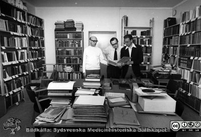 Sydsvenska Medicinhistoriska Sällskapets bibliotek
Medicinhistoriska samlingar i Lund före 1987, troligen i början av 1970-talet. Foto monterat på pappskiva. Från vänster Bengt Lindahl, Anders Grönvall, Bengt Lindskog.
Nyckelord: Foto;Monterat;Lund;Lasarett;USiL;Universitetssjukhus;Kapsel 07