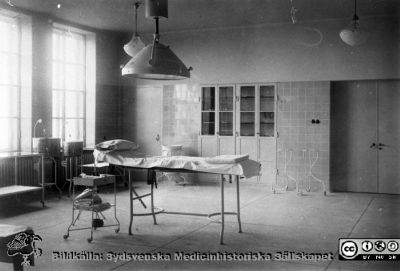Kirurgisk operationsal på Lasarettet i Lund
Kanske en poliklinisk sal, för de stora operationssalarna för inneliggande paienter hade större väggfönster och därtill också takfönster. Lampor och övrig utrustning antyder att bilden tagits på 1900-talets första halva, men bilden är bara märkt som "gammal".
Nyckelord: Lasarett;Lund;Kirurgi;Operation;Operationssal