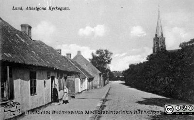 Fotografiskt vykort som visar västra delen av Allhelgona Kyrkogata i Lund
Från repronegativ i lasarettsfotografernas pärm "Gammalt A". Foto efter 1891, då Allhelgonakyrkan blev färdig, den kyrka som syns i bilden. Husen på den östra delen av gatan (rimligen delen bakom fotografen och kanske de närmaste husen) revs omkring 1918 för att ge plats för en utvidgning av södra lasarettsområdet. Den västra delen av gatan är år 2014 bebyggd med andra hus. Bild SMHS2428 visar samma vykort.
Nyckelord: Kyrka;Gata;Allhelgona;Lund