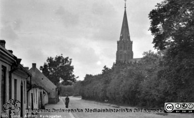 Västra delen av Allhelgona Kyrkogata i Lund
Från 35 mm repronegativ i lasarettsfotograferna i Lunds arkiv. Pärm "Gammalt A". Foto efter 1891, då Allhelgonakyrkan blev färdig, den kyrka som syns i bilden. Husen på den östra delen av gatan (rimligen delen bakom fotografen) revs omkring 1918 för att ge plats för en utvidgning av södra lasarettsområdet. Den västra delen av gatan är år 2014 bebyggd med andra hus.
Nyckelord: Lund;Allhelgona;Kyrka;Gata