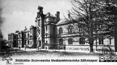 Kirurgiska kliniken i Lund, rimligen i slutet på 1800-talet.
Från repronegativ i lasarettsfotografernas pärm "Gammalt A". Reprofoto av fotografiskt vykort av 1867-68 års kirurgiska klinik i Lund från slutet av 1800-talet. Fasad mot öster. Notera hästdroskan. Stilen påminner om Lina Jonns.
Nyckelord: Lasarettet;Lund;Universitetssjukhus;Universitet;Kirurgisk;Klinik