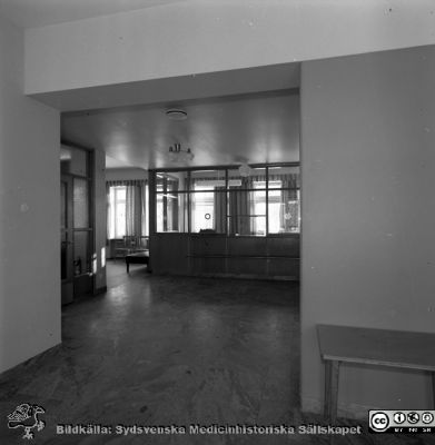 Reumatologiska kliniken 1958, med nybyggd flygel åt öster
Lasarettets bildarkiv, Album "gamla bilder". A. Reum. Klin, mars, 1958. Entré till mottagning med anmälningsluckor. Från negativ
Nyckelord: Lasarettet;Lund;Universitet;Universitetssjukhus;Reumatologi;Klinik;Mottagning;Expedition