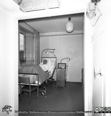 Reumatologiska kliniken 1958, med nybyggd flygel åt öster
Lasarettets bildarkiv, Album "gamla bilder". A. Reum. Klin, mars, 1958. Vårdrum med en patient synlig. Från negativ
Nyckelord: Lasarettet;Lund;Universitet;Universitetssjukhus;Reumatologisk;Rheumatologisk;Klinik;Vårdrum