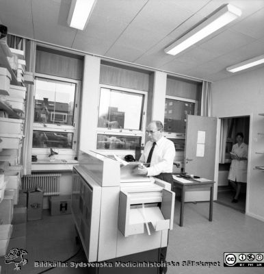 Vaktmästare S. Lantz vid kopiatorn i administrationshuset 1970
USiL Pärm "Div. tagningar, 1960 och t.v.". 2 okt 1970. Bilder för "Aktuell information". Vaktmästare S. Lantz vid kopiatorn i administrationshuset. Från negativ
Nyckelord: Lund;Lasarett;Universitet;Universitetssjukhus;Administration;Kopiator;Vaktmästare;Kontor