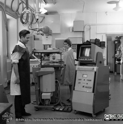 Docent Tord Olin på experimentalröntgen i Lund 1969
Pärm "USiL div. tagningar 1960 och t.v.". Experimentalröntgen 1969. Docent (senare professor i Malmö) Tord Olin med röntgenassistent Britt Nihlén vid en röntgenapparat med elektronisk bildförstärkare och monitor. Från negativ
Nyckelord: Lund;Lasarett;Universitet;Universitetssjukhus;Rtg;Experimentalröntgen;Angiografi;Kassettväxlare;Bildförstärkare