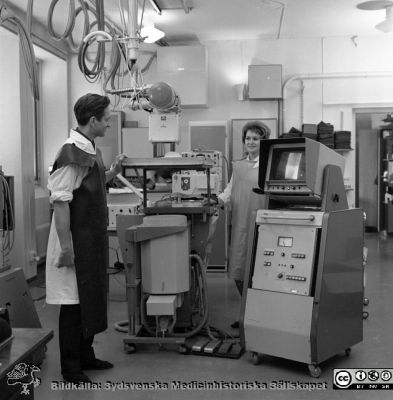 Docent Tord Olin på experimentalröntgen i Lund 1969
Pärm "USiL div. tagningar 1960 och t.v.". Experimentalröntgen 1969. Docent (senare professor i Malmö) Tord Olin med röntgenassistent Britt Nihlén vid en röntgenapparat med elektronisk bildförstärkare och monitor. Från negativ
Nyckelord: Lund;Lasarett;Universitet;Universitetssjukhus;Rtg;Experimentalröntgen;Angiografi;Kassettväxlare;Bildförstärkare