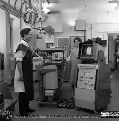 Docent Tord Olin på experimentalröntgen i Lund 1969
Pärm "USiL div. tagningar 1960 och t.v.". Experimentalröntgen 1969. Docent (senare professor i Malmö) Tord Olin med röntgenassistent Britt Nihlén vid en röntgenapparat med elektronisk bildförstärkare och monitor. Från negativ
Nyckelord: Lund;Lasarett;Universitet;Universitetssjukhus;Rtg;Experimentalröntgen;Angiografi;Kassettväxlare;Bildförstärkare