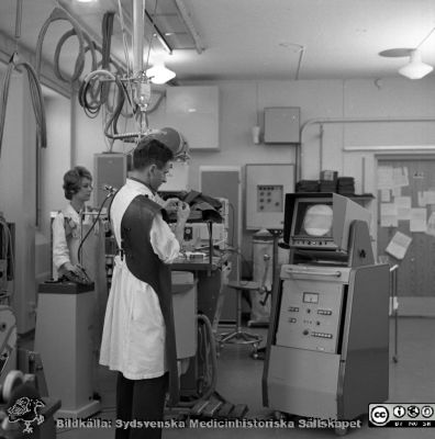 Docent Tord Olin på experimentalröntgen i Lund 1969
Pärm "USiL div. tagningar 1960 och t.v.". Experimentalröntgen 1969. Docent (senare professor i Malmö) Tord Olin med röntgenassistent Britt Nihlén vid en röntgenapparat med elektronisk bildförstärkare och monitor. Från negativ
Nyckelord: Lund;Lasarett;Universitet;Universitetssjukhus;Rtg;Experimentalröntgen;Angiografi;Bildförstärkare