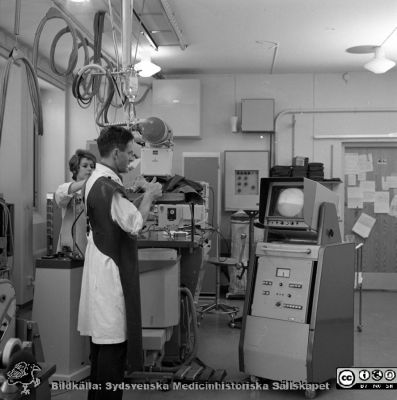 Docent Tord Olin på experimentalröntgen i Lund 1969
Pärm "USiL div. tagningar 1960 och t.v.". Experimentalröntgen 1969. Docent (senare professor i Malmö) Tord Olin med röntgenassistent Britt Nihlén vid en röntgenapparat med bildförstärkare och filmkassettväxlare. Från negativ
Nyckelord: Lund;Lasarett;Universitet;Universitetssjukhus;Rtg;Experimentalröntgen;Angiografi;Kassettväxlare;Bildförstärkare