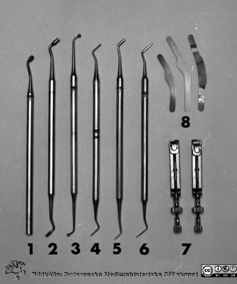 Instrumentsats för uppdukning på centraltandpolikliniken 1969
Pärm "USiL div. tagningar. 1960 och t.v.". Centraltandpol. 22/10 1969. Tandl. Dahl. instrumentdukn. Från negativ.
1. Amalgamstoppare, enkel
2. Amalgamstoppare, dubbel
3. Kulstoppare, stor
4. Kuklstoppare, liten
5. Carver enl. Wards,
6. Carver enl. Nyström
7. Matrishållare
8. Rostfria matrisband, 2 x 3 sorter
Nyckelord: Lund;Lasarett;Universitet;Universitetssjukhus;Dental;Tandpoliklinik;Tandläkare;Oral;Kirurgi;Instrument