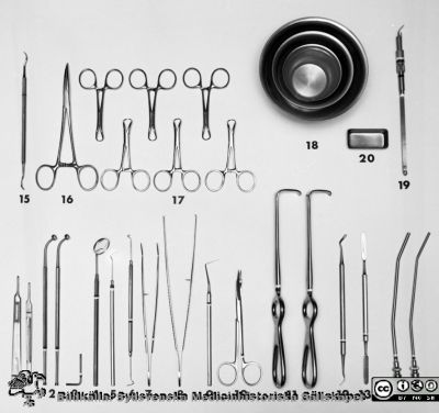Instrumentsats för uppdukning på centraltandpolikliniken 1969
Pärm "USiL div. tagningar. 1960 och t.v.". Centraltandpol. 22/10 1969. Tandl. Dahl. instrumentdukn. Från negativ.
1. Skalpellskaft, korta
2. Skalpellskaft enl. Blake
3. Nyckel till d:o
4. Spegel
5. Sond, rak
6. Sond, böjd
7. Pincett, tand
8. Pincett, klo
9. Sond, fickmätnings
10. Sax spetsig, 12 cm
11. Hakar enl. Langenbeck
12. Planinstrument
13. Spatel
14. Sugrör 4 mm
14. Sugrör 3 mm
15. Hawk-Beek Crane-Kaplan N6, dubbeländad
16. Peang, böjd 16 cm
17. Handduksklämmor
18. Rostfri kopp, 12 cm, 9 cm och 6,5 cm
19. Cavitronhandtag
20. Borrkopp

16. 
Nyckelord: Lund;Lasarett;Universitet;Universitetssjukhus;Dental;Tandpoliklinik;Tandläkare;Oral;Kirurgi;Instrument