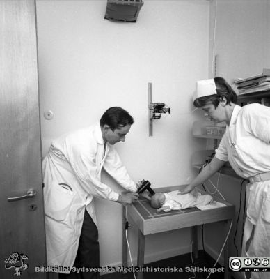 Neonatologen Nils Svenningsen på barnkliniken i Lund 1969
Pärm "USiL div. tagningar. 1960 och t.v.". 1969. Omärkt bild. Från negativ. Neonatologen docent Nils Svenningsen mäter något på ett spädbarn.
Nyckelord: Lund;Lasarett;Universitet;Universitetssjukhus;Neonatologi;Pediatrik;BB;KK