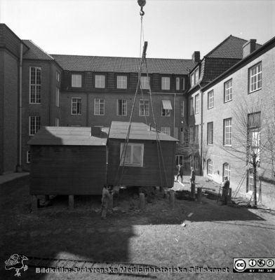 Forskningsbaracken på innergården i den tidigare medicinska kliniken tas bort
Pärm "USiL div. tagningar. 1960 och t.v.". Foto 1968. Från negativ. - Bildserien visar rimligen borttagningen av den barack med forskningsutrymmen som något decennium tidigare hade satts på en av mediciniska klinikens innergårdar. Medicinska klinkiken hade 1968 flyttat in i det nya centralblocket, vilket bör ha varit anledningen till att baracken togs bort.
Nyckelord: Lund;Lasarett;Sjukhus;Universitet;Universitetssjukhus;Intern;Medicin;Klinik;Forskning;Barack