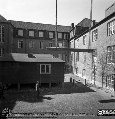 Forskningsbaracken på innergården i den tidigare medicinska kliniken tas bort
Pärm "USiL div. tagningar. 1960 och t.v.". Foto 1968. Från negativ. - Bildserien visar rimligen borttagningen av den barack med forskningsutrymmen som något decennium tidigare hade satts på en av mediciniska klinikens innergårdar. Medicinska klinkiken hade 1968 flyttat in i det nya centralblocket, vilket bör ha varit skälet till att baracken togs bort. Fil SMHS2668 kommer från samma negativ.
Nyckelord: Lund;Lasarett;Sjukhus;Universitet;Universitetssjukhus;Intern;Medicin;Klinik;Forskning;Barack