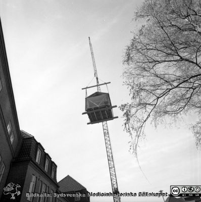 Forskningsbaracken på innergården i den tidigare medicinska kliniken tas bort
Pärm "USiL div. tagningar. 1960 och t.v.". Foto 1968. Från negativ. - Bildserien visar rimligen borttagningen av den barack med forskningsutrymmen som något decennium tidigare hade satts på en av mediciniska klinikens innergårdar. Medicinska klinkiken hade 1968 flyttat in i det nya centralblocket, vilket nog var orsaken till att baracken togs bort.
Nyckelord: Lund;Lasarett;Sjukhus;Universitet;Universitetssjukhus;Intern;Medicin;Klinik;Forskning;Barack