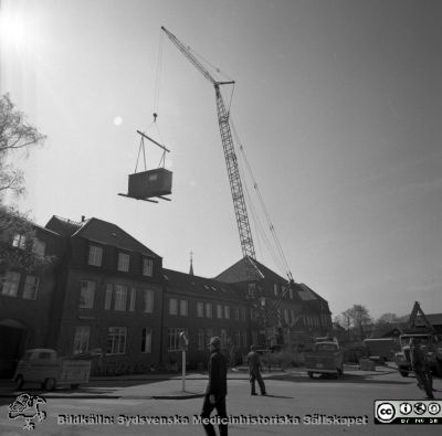 Forskningsbaracken på innergården i den tidigare medicinska kliniken tas bort
Pärm "USiL div. tagningar. 1960 och t.v.". Foto 1968. Från negativ. - Bildserien visar rimligen borttagningen av den barack med forskningsutrymmen som något decennium tidigare hade satts på en av mediciniska klinikens innergårdar. Medicinska klinkiken hade 1968 flyttat in i det nya centralblocket, och baracken behövdes inte mer.
Nyckelord: Lund;Lasarett;Sjukhus;Universitet;Universitetssjukhus;Intern;Medicin;Klinik;Forskning;Barack