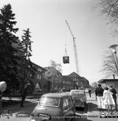 Forskningsbaracken på innergården i den tidigare medicinska kliniken tas bort
Pärm "USiL div. tagningar. 1960 och t.v.". Foto 1968. Från negativ. - Bildserien visar rimligen borttagningen av den barack med forskningsutrymmen som något decennium tidigare hade satts på en av mediciniska klinikens innergårdar. Medicinska klinkiken hade 1968 flyttat in i det nya centralblocket, och baracken behövdes inte längre.
Nyckelord: Lund;Lasarett;Sjukhus;Universitet;Universitetssjukhus;Intern;Medicin;Klinik;Forskning;Barack