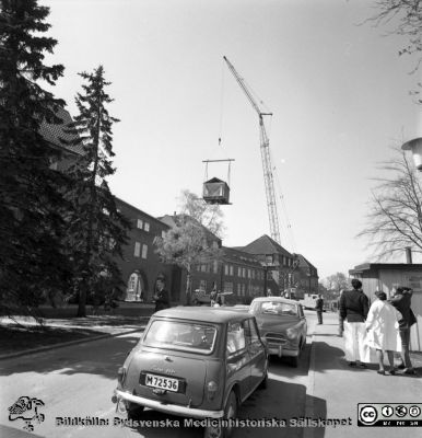 Forskningsbaracken på innergården i den tidigare medicinska kliniken tas bort
Pärm "USiL div. tagningar. 1960 och t.v.". Foto 1968. Från negativ. - Bildserien visar rimligen borttagningen av den barack med forskningsutrymmen som något decennium tidigare hade satts på en av mediciniska klinikens innergårdar. Medicinska klinkiken hade 1968 flyttat in i det nya centralblocket, och baracken behövdes inte längre.
Nyckelord: Lund;Lasarett;Sjukhus;Universitet;Universitetssjukhus;Intern;Medicin;Klinik;Forskning;Barack