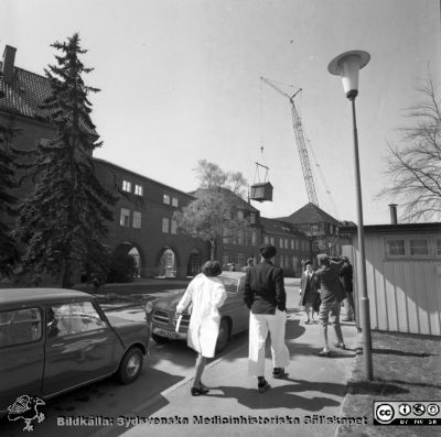 Forskningsbaracken på innergården i den tidigare medicinska kliniken tas bort
Pärm "USiL div. tagningar. 1960 och t.v.". Foto 1968. Från negativ. - Bildserien visar rimligen borttagningen av den barack med forskningsutrymmen som något decennium tidigare hade satts på en av mediciniska klinikens innergårdar. Medicinska klinkiken hade 1968 flyttat in i det nya centralblocket, och baracken behövdes inte mer.
Nyckelord: Lund;Lasarett;Sjukhus;Universitet;Universitetssjukhus;Intern;Medicin;Klinik;Forskning;Barack