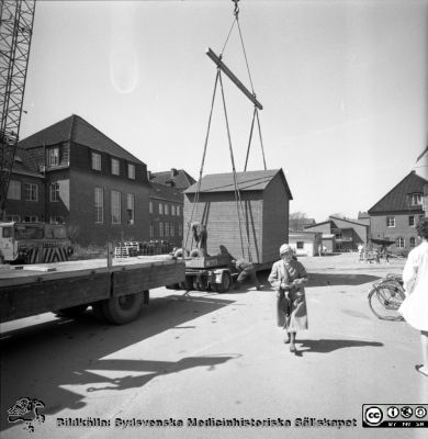 Forskningsbaracken på innergården i den tidigare medicinska kliniken tas bort
Pärm "USiL div. tagningar. 1960 och t.v.". Foto 1968. Från negativ. - Bildserien visar rimligen borttagningen av den barack med forskningsutrymmen som något decennium tidigare hade satts på en av mediciniska klinikens innergårdar. Medicinska klinkiken hade 1968 flyttat in i det nya centralblocket, och baracken behövdes inte längre.
Nyckelord: Lund;Lasarett;Sjukhus;Universitet;Universitetssjukhus;Intern;Medicin;Klinik;Forskning;Barack