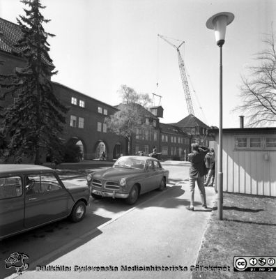 Forskningsbaracken på innergården i den tidigare medicinska kliniken tas bort
Pärm "USiL div. tagningar. 1960 och t.v.". Foto 1968. Från negativ. - Bildserien visar rimligen borttagningen av den barack med forskningsutrymmen som något decennium tidigare hade satts på en av mediciniska klinikens innergårdar. Medicinska klinkiken hade 1968 flyttat in i det nya centralblocket, och baracken behövdes inte mer.
Nyckelord: Lund;Lasarett;Sjukhus;Universitet;Universitetssjukhus;Intern;Medicin;Klinik;Forskning;Barack