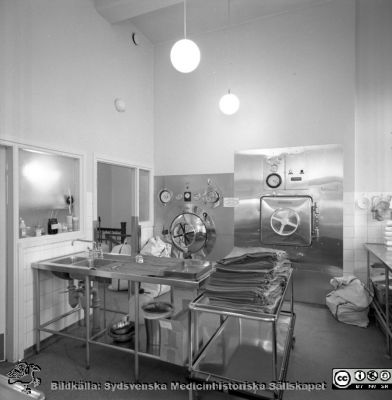 Från en serie bilder tagna 1968 när sjukvården efter mer än 100 år skulle lämna Gamla Kirurgen i Lund
Pärm "USiL div. tagningar. 1960 och t.v.". Omärkt bild. Foto 1968. Från negativ. 
Steriliseringen, gamla kirurgiska kliniken, Lasarettet i Lund 1968. Från samma negativ som bild SMHS2539.
Nyckelord: Lund;Lasarettet;Universitetssjukhus;Universitet;Kirurgi;Kirurgisk;Klinik;Autoklav;Sterilisering