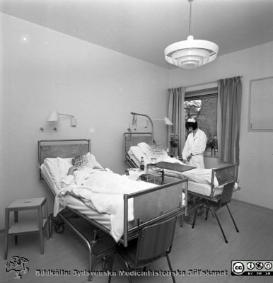 Två kvinnliga patienter på halvenskilt rum på Lasarettet i Lund 1967
Omärkt bild 1967. Från negativ. Halvenskilt rum. Troligast  på dåvarande kirurgiska kliniken som strax skulle stängas.
Nyckelord: Lund;Lasarett;Universitet;Universitetssjukhus;Klinik;Kirurgisk