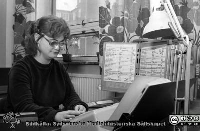 Telefonväxeln på Lasarettet i Lund 1980
Lasarettsfotograferna i Lund. Pärm "Negativ, 80:1." 33. Telefonväxeln, Lasarettet i Lund.  Exempel på telefonistens hjälpmedel före datorernas intåg. På bild Ann-Christine Bengtsson, en synskadad kvinna som tjänstgjorde i många år. Hon var snabb och duktigt i sitt arbete, och hade vacker röst. Foto 80-02-05. Från negativ.
Nyckelord: Lasarettet;Lund;Universitetssjukhus;USiL;Administration;Telefon;Växel