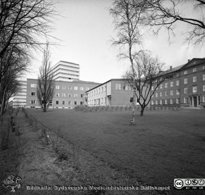 Barnpsykiatriska kliniken från öster
Lasarettsfotograferna i Lund. Pärm "Div. tagningar, 1960 och t.v.". Foto 20/4 1967.  Från 1986/87 ögonkliniken B. Vuxenpsykiatriska kliniken till höger (från 2007 Wigerthuset).  Från negativ.
Nyckelord: Lasarett;Lund;Universitet;Universitetsklinik USiL;USiL;Ögon;Oftalmologi;Klinik;Barnpsykiatri;Vuxenpsykiatri