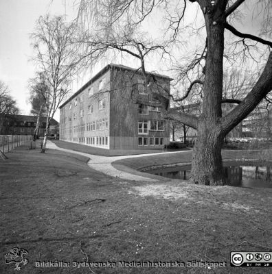 Östra delen av reumatologiska kliniken i Lund 1967
Pärm "Div. tagningar, 1960 och t.v.". Reumaten, 20/4-67. Fasader mot söder och öster. Den gamla ankdammen / märgelgraven i förgrunden i sjukhusparken. Badbassängen för rörelsebehandling är ännu inte byggd. Från negativ.
Nyckelord: Lund;Lasarett;Universitet;Universitetssjukhus;USiL;Reumatologisk;Rheuma;Klinik