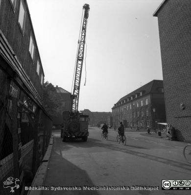 Cetralblocket i Lund byggs 1965
Pärm "Div. tagningar, 1960 och t.v.". Byggbodar och lyftkran vid bygget av centralblocket. Dåvarande ortopediska kliniken till vänster bortom bodarna och öronkliniken till höger. Radiologiska kliniken i bildens högra kant. Foto 25 september 1965. Från negativ.
Nyckelord: Lund;Lasarett;Universitet;Universitetssjukhus;USiL;Centralblocket;Bygge