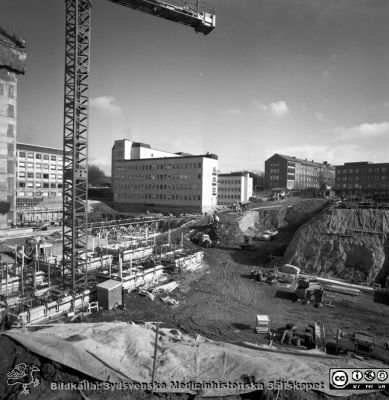 Cetralblocket i Lund byggs 1965
Pärm "Div. tagningar 1960 och t.v.". Mars, 1965. Centralblocket på Lasarettet i Lund har just börjat byggas. Längt till vänster det norra hissbatteriets torn framför det tidigare byggda AB-blocket. I centrum det tidigare byggda E-blockets första del. Till höger därom psykiatriska och barnpsykiatriska klinikerna. Från negativ.
Nyckelord: Lund;Lasarett;Universitet;Universitetssjukhus;Centralblocket;USiL;Bygge;Grundläggning;Hissbatteri;Torn