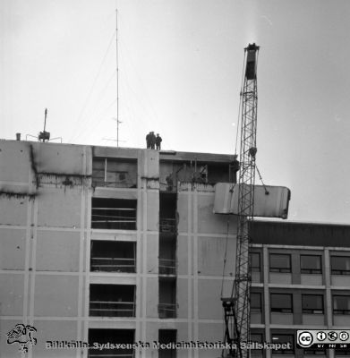 Cetralblocket i Lund byggs 1964
Pärm "Div. tagningar 1960 och t.v.". Foto 1964. AB-blocket byggdes med ett trapphus som var tänkt byggas ihop med den kommande centralbyggnaden (C-huset i Blocket). Här öppnas trapphusets fasad i AB-blocket för den kommande sammanfogningen. Från negativ.
Nyckelord: Lund;Lasarett;Universitet;Universitetssjukhus;Centralblocket;USiL;Bygge