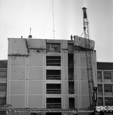 Cetralblocket i Lund byggs 1964
Pärm "Div. tagningar 1960 och t.v.". Foto 1964. AB-blocket byggdes med ett trapphus som var tänkt byggas ihop med den kommande centralbyggnaden (C-huset i Blocket). Här öppnas trapphusets fasad i AB-blocket för den kommande sammanfogningen. Från negativ.
Nyckelord: Lund;Lasarett;Universitet;Universitetssjukhus;Centralblocket;USiL;Bygge