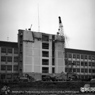 Lasarettet i Lund 1964. Centralblocket byggs
Pärm "Div. tagningar 1960 och t.v.". Foto 1964. AB-blocket byggdes med ett trapphus som var tänkt byggas ihop med den kommande centralbyggnaden (C-huset i Blocket). Här öppnas trapphusets fasad i AB-blocket för den kommande sammanfogningen. Från negativ.
Nyckelord: Lasarettet;Lund;Universitet;Universitetssjukhus;USiL;Bygge