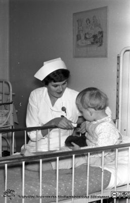 Lasarettet i Lund. Barn på öronkliniken 1963
Lasarettet i Lund. Lasarettsfotograferna. Lund. Pärm "Div. tagningar 1960 och t.v.". Öron 63. Troligen ett barn med barnsköterska 1963, öronkliniken i Lund. Från negativ. Ej monterat
Nyckelord: Lund;Lasarett;Universitetssjukhus;Universitet;USiL;Öron;ÖNH;ENT;Hals;Klinik;Barn