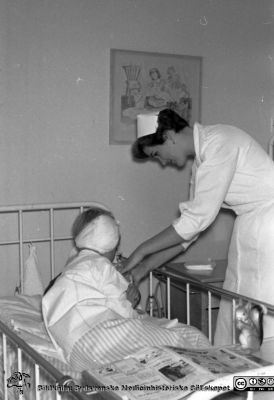 Lasarettet i Lund. Barn på öronkliniken 1963
Lasarettet i Lund. Lasarettsfotograferna. Lund. Pärm "Div. tagningar 1960 och t.v.". Öron 63. Troligen ett barn med barnsköterska 1963, öronkliniken i Lund. Från negativ. Ej monterat.
Nyckelord: Lund;Lasarett;Universitetssjukhus;Universitet;USiL;Öron;ÖNH;ENT;Näsa;Hals;Klinik;Barn