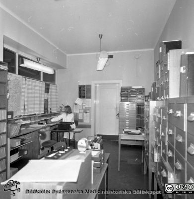 Lasarettet i Lund år 1967. Öronklinikens expedition.
Lasarettsfotograferna. Lund. Pärm "Div. tagningar, 1960 och t.v.". Foto 1967. Sekreterare på öronklinikens skrivexpedition och journalarkiv. Från negativ
Nyckelord: Lund;Lasarett;Universitet;Universitetssjukhus;USiL;Öron;ÖNH;Öron-näsa-hals;Otologi;Otiatri;Administration;Sekreterare;Expedition