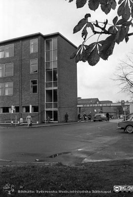 Radiologiska klinikens fasad mot söder en höstdag 1961. 
Lasarettsfotograferna. Lund. Pärm "Div. tagningar, 1960 och t.v.". Lasarettets exteriörer. Betongbaldakinen vid entrén finns kvar. Från negativ. 
Nyckelord: Lasarett;Lund;Universitet;Universitetssjukhus;USiL;Radiologisk;Onkologisk;Klinik;Gustav V;Jubileum