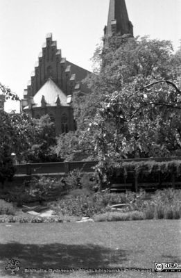 Parken mellan förlossningsavdelningen och dåvarande medicinkliniken 1960
Lasarettsfotograferna. Lund. Pärm "Div. tagningar, 1960 och t.v.". 16. Trädgården 1960 strax norr om förlossningsavdelningen med Allhelgonakyrkan i bakgrunen. En liten statyett i dammen.  Från negativ.
Nyckelord: Lasarett;Lunga;Universitetssjukhus;USiL;Medicin;Klinik;Allhelgonakyrkan;Staty;Damm;Park;Trädgård