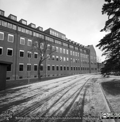 Gamla ortopediska kliniken, nu 1976 ombyggd och utökad till ny kvinnoklinik. 
Sjukhusfotograferna i Lund. Pärm negativ, S/V. 1976.	42. Foto från sydväst. Gamla ögonkliniken anas i bakgrunden.Till vänster i bild hörnet på lasarettskirosken, som ännu var brungrå. Från negativ.
Nyckelord: Lasarett;Lund;Universitet;Universitetssjukhus;USiL;Kvinnoklinik;Klinik;Gynekologisk;Barnbördsklinik;BB